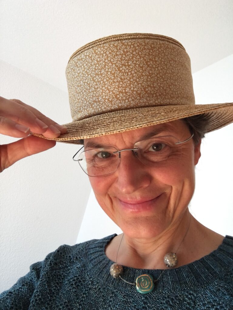 Person mit Strohhut lächelt in die Kamera