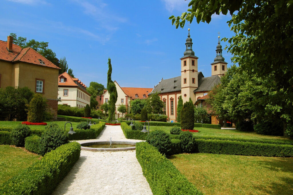 Historische Kirche mit gepflegtem Garten und Bäumen