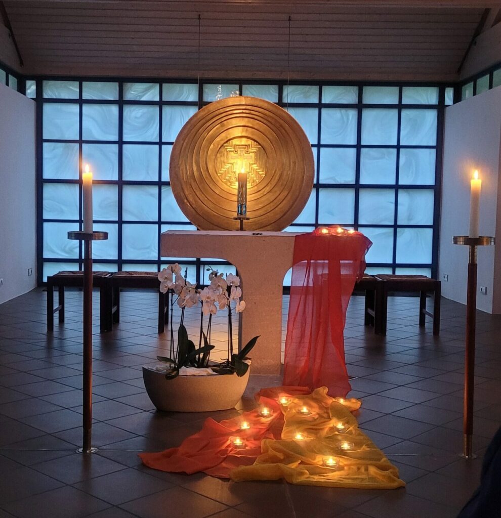 Altar mit Kerzen und Blumen in Kirche