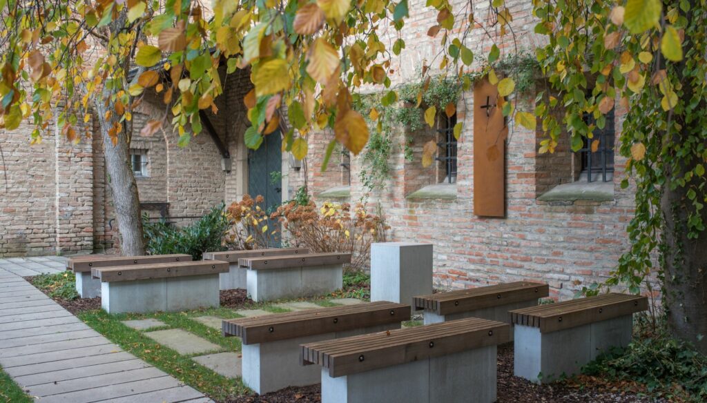 Steinbänke im herbstlichen Garten mit Ziegelwand
