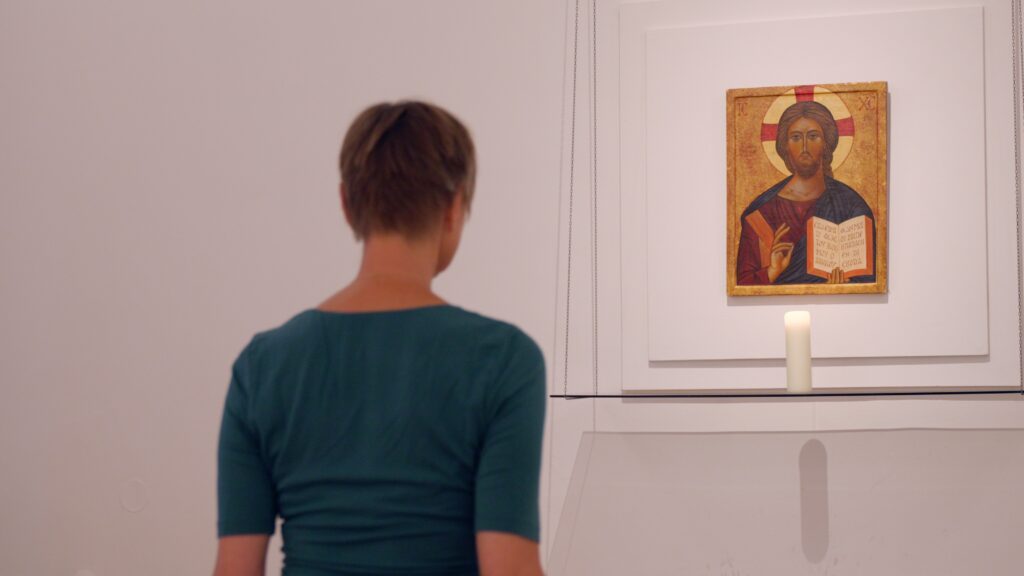 Person betrachtet religiöses Bild in einer Galerie