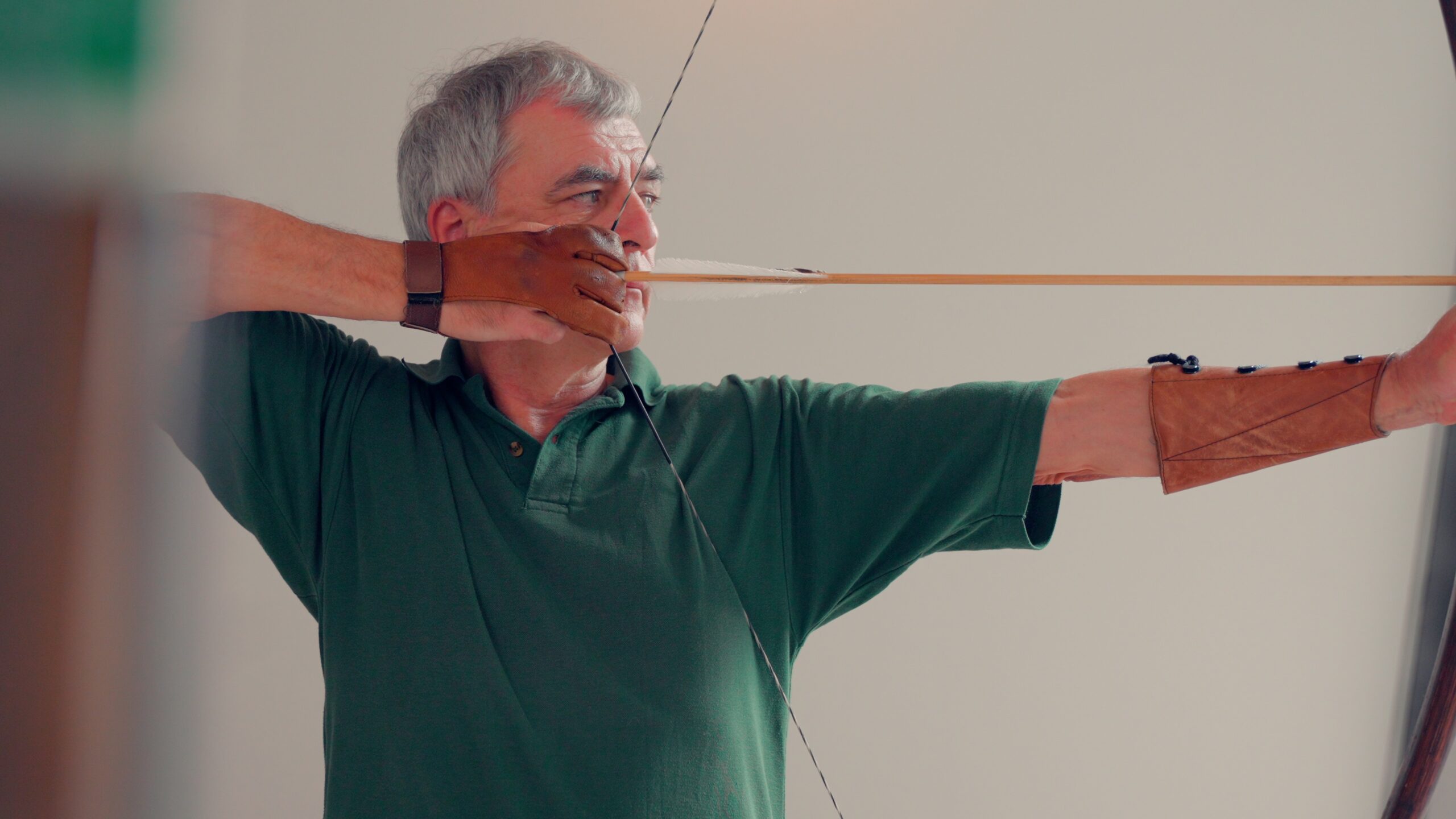 Älterer Mann beim Bogenschießen mit Pfeil und Bogen