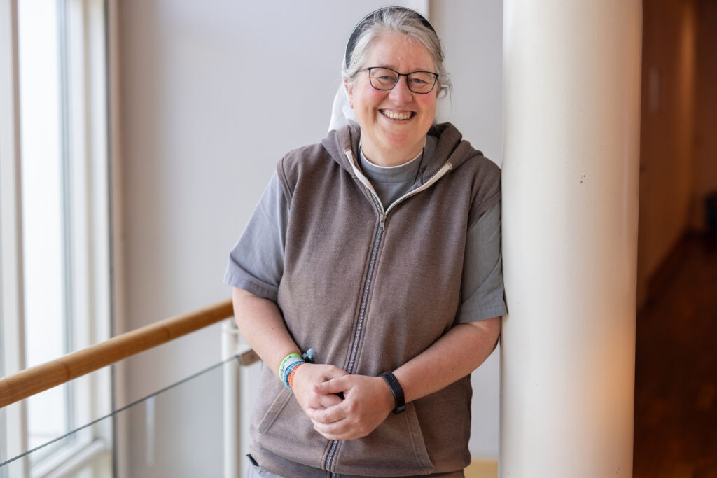 Person lächelt in einem modernen Gebäudeumfeld.