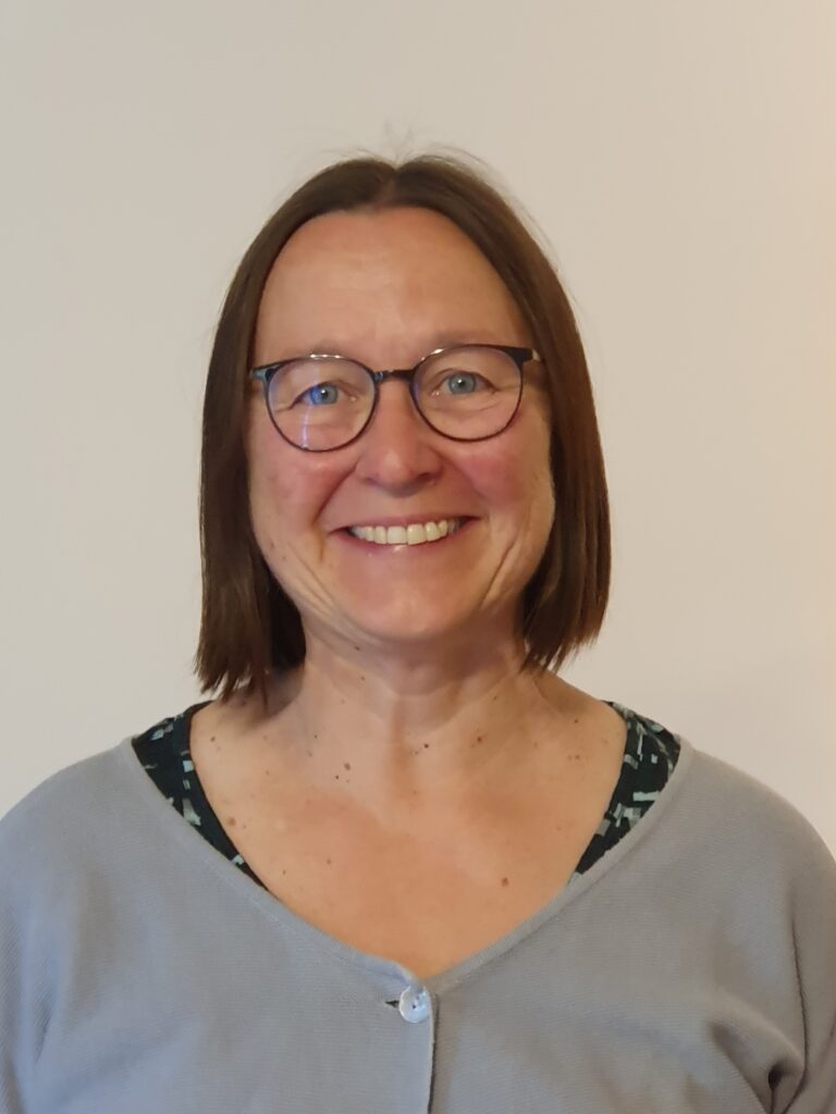 Unbekannte lächelnde Frau mit Brille und braunen Haaren