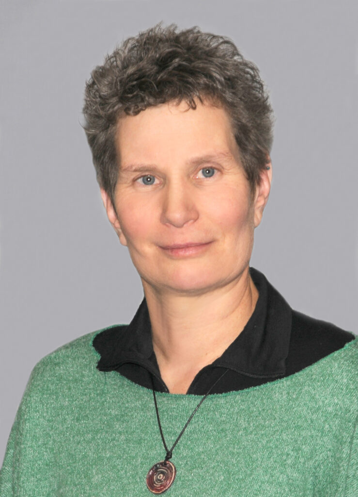 Porträt einer Frau mit kurzem Haar in Grün.