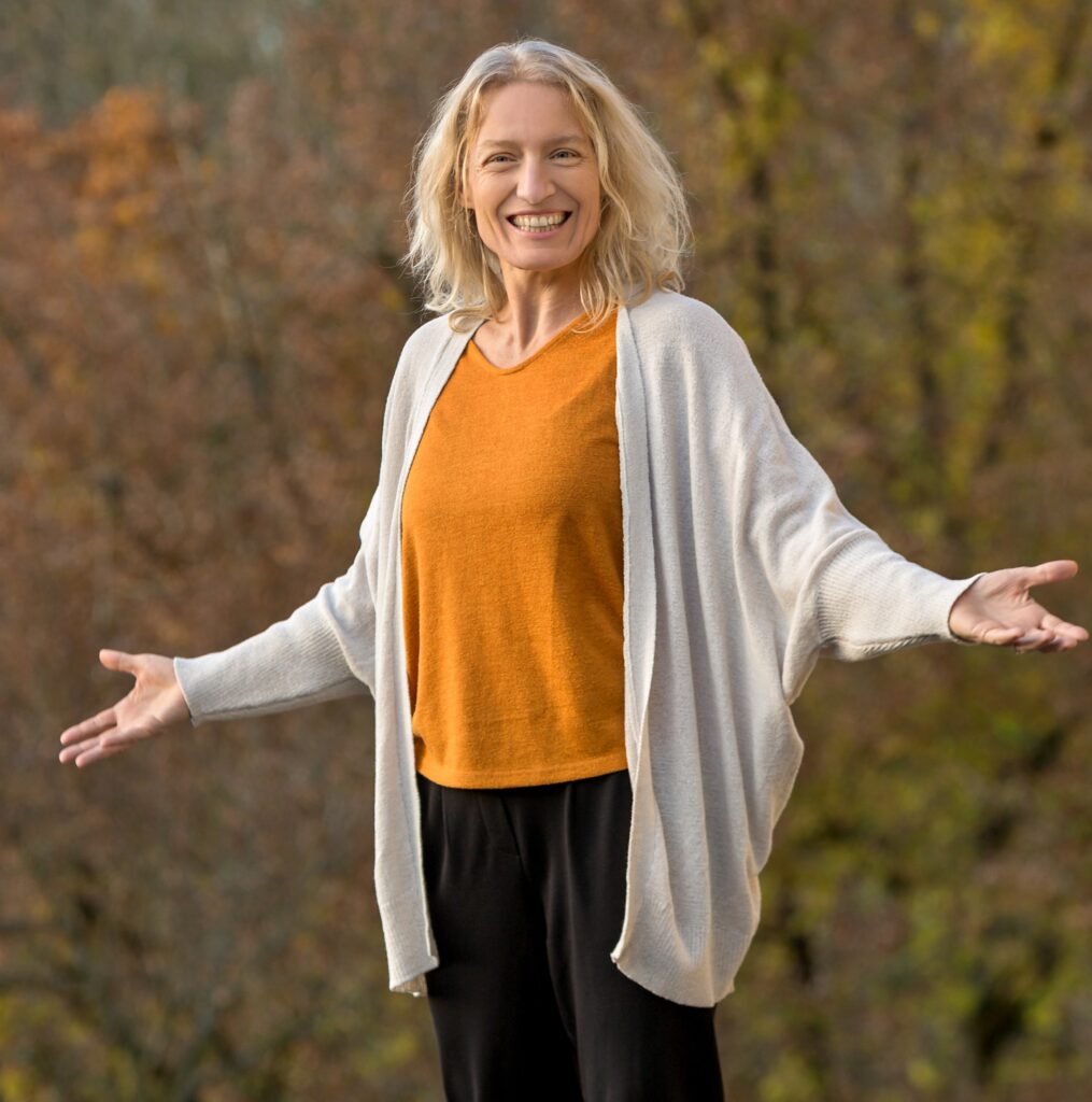 Lächelnde Frau im Freien mit Herbsthintergrund